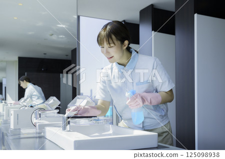 一名年輕的女清潔工正在擦拭辦公大樓浴室的水槽。照片提供:東京電子專門學校、電波學園 一名年輕的女清潔工正在擦拭辦公大樓浴室的水槽。照片提供:東京電子專門學校、電波學園 125098938