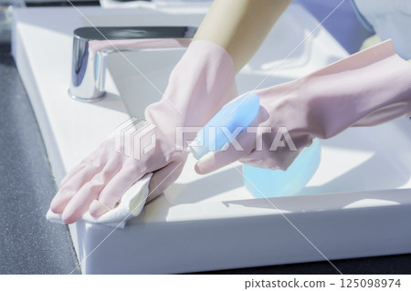 一名年輕女清潔工的手正在擦拭辦公大樓浴室的水槽。照片提供：電波學園東京電子專門學校 125098974