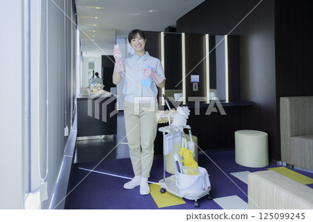 Full-body portrait of a young female office building cleaner. Photo courtesy of Tokyo Electronics College, Denpa Gakuen Corporation. 125099245