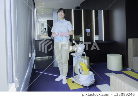 Full-body portrait of a young female office building cleaner. Photo courtesy of Tokyo Electronics College, Denpa Gakuen Corporation. 125099246