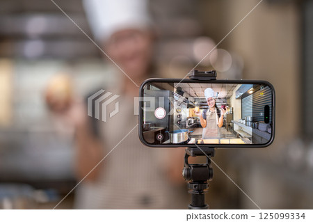 Smartphone Capturing Chef Filming Cooking Video in Kitchen 125099334