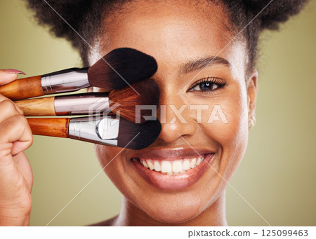Black woman, makeup brush and smile in studio for beauty portrait, wellness and cosmetics by backdrop. African woman, model and face with cosmetic tools, hand or happy for skincare by background 125099463