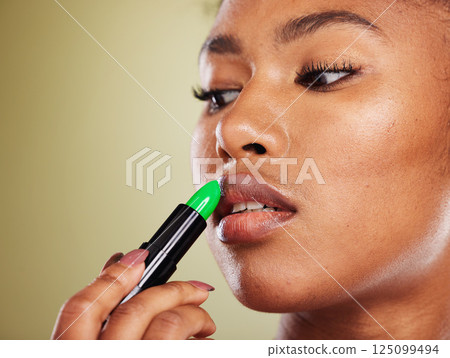 Lipstick, black woman and mouth, makeup and skincare, cosmetics and aesthetics on green studio background. African model face, advertising beauty product and lip color, luxury fashion and lip balm Lipstick, black woman and mouth, makeup and skincare, cosmetics and aesthetics on green studio background. African model face, advertising beauty product and lip color, luxury fashion and lip balm 125099494