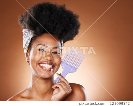 Hair care, beauty and black woman with afro comb for a routine in studio with mockup space. Happy, smile and portrait of young African model with natural hair and product isolated by brown background 125099542