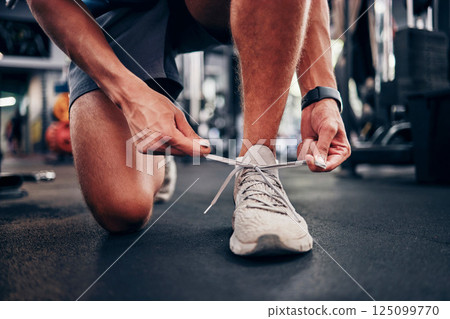 Gym, hands and man tie shoes getting ready for workout, training or exercise. Fitness, sports or male athlete in fitness center preparing for running, cardio or bodybuilding practice in health studio 125099770