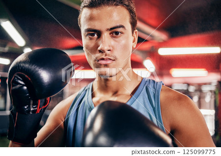 Fitness, boxing gloves and portrait of an athlete training for a fighting match or competition. Sports, motivation and man boxer in a gym to workout, exercise or practice for a martial arts fight. Fitness, boxing gloves and portrait of an athlete training for a fighting match or competition. Sports, motivation and man boxer in a gym to workout, exercise or practice for a martial arts fight. 125099775