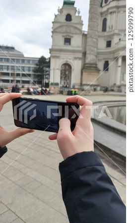 Hands holding a smartphone capturing a photo Hands holding a smartphone capturing a photo 125099790