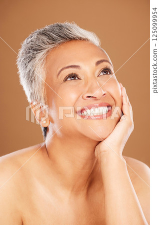 Wellness, skincare and senior woman with beauty idea, health and vision for cosmetic care against a brown studio background. Makeup, smile and elderly cosmetics model thinking of dermatology Wellness, skincare and senior woman with beauty idea, health and vision for cosmetic care against a brown studio background. Makeup, smile and elderly cosmetics model thinking of dermatology 125099954