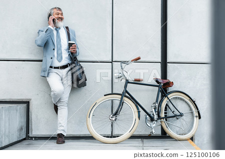 Bicycle, phone call and business man in city for communication, networking and carbon footprint travel marketing update with smile. Happy, healthy senior corporate manager coffee, bike and cellphone Bicycle, phone call and business man in city for communication, networking and carbon footprint travel marketing update with smile. Happy, healthy senior corporate manager coffee, bike and cellphone 125100106