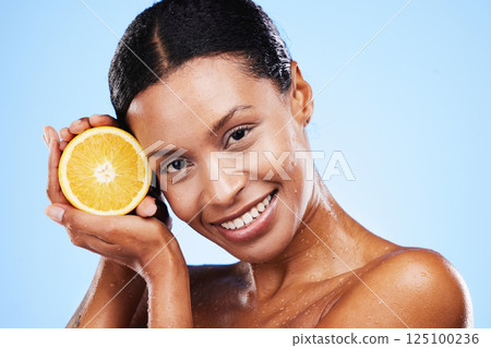 Skincare, beauty and orange fruit for black woman in studio for cosmetics, vitamin c and dermatology benefits with water drops on skin. Portrait, face and smile of model with natural product for skin Skincare, beauty and orange fruit for black woman in studio for cosmetics, vitamin c and dermatology benefits with water drops on skin. Portrait, face and smile of model with natural product for skin 125100236