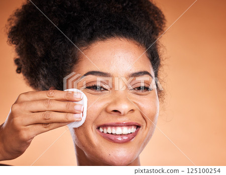 Face, skincare and black woman with cotton pad on orange studio background mockup. Happy, health and female model with product for cleaning facial makeup, cosmetics or beauty products with mock up 125100254