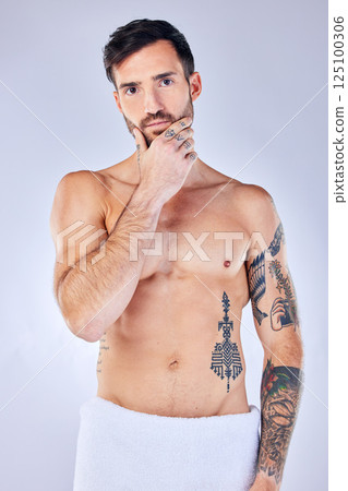 Man, thinking and tattoo with a towel, shower and sexy against grey studio background with mockup space. Portrait, idea and male model with creative body ink, art and after a bath, clean or beauty 125100306