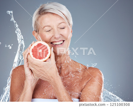 Skincare, water and portrait of old woman with grapefruit in gray background studio for wellness. Beauty, water splash and senior female with fruit for organic, natural and healthy cosmetic products Skincare, water and portrait of old woman with grapefruit in gray background studio for wellness. Beauty, water splash and senior female with fruit for organic, natural and healthy cosmetic products 125100308