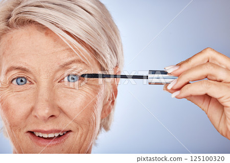 Portrait, makeup and senior woman mascara for eye, skincare or wellness for natural beauty against blue studio background. Cosmetics, mature lady or elderly female with eyelashes, smile and confident Portrait, makeup and senior woman mascara for eye, skincare or wellness for natural beauty against blue studio background. Cosmetics, mature lady or elderly female with eyelashes, smile and confident 125100320