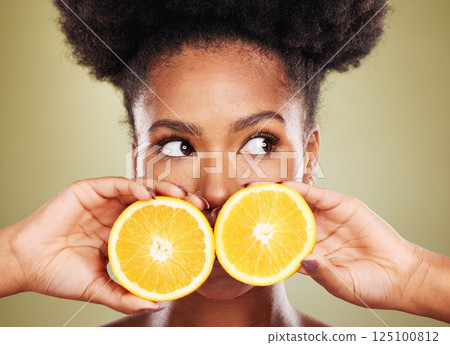 Black woman, face or thinking of orange fruit skincare, vitamin c dermatology or organic facial ideas on green studio background. Zoom, beauty model or natural hair and citrus healthy food wellness Black woman, face or thinking of orange fruit skincare, vitamin c dermatology or organic facial ideas on green studio background. Zoom, beauty model or natural hair and citrus healthy food wellness 125100812