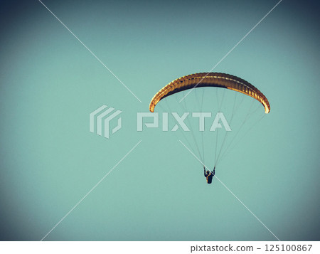 Paraglider flying in blue sky. Paraglider flying in blue sky. 125100867
