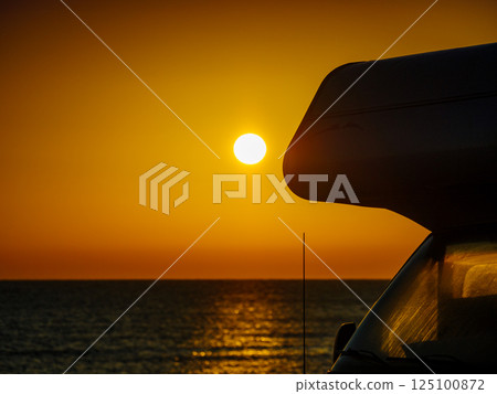 Camper car on beach at sunrise 125100872