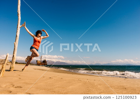 Tourist woman on beach enjoying vacation 125100923