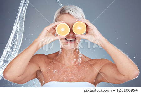 Water splash, fruit and senior skincare of a woman holding orange for vitamin c and skin glow. Beauty, clean detox and cosmetic health wellness of a model happy about shower, diet and nutrition 125100954