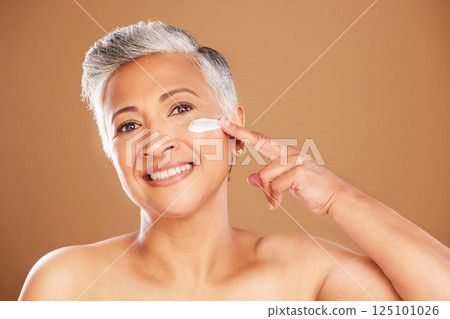 Face, skincare and senior woman with cream in a daily grooming treatment with beauty cosmetics in studio. Marketing, mockup and mature person applying facial sunscreen lotion or dermatology products Face, skincare and senior woman with cream in a daily grooming treatment with beauty cosmetics in studio. Marketing, mockup and mature person applying facial sunscreen lotion or dermatology products 125101026