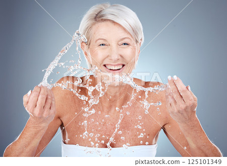 Water splash, mature woman cleaning face on gradient background for health, beauty and skin care routine. Skincare, cosmetics and portrait of happy senior woman with smile washing in water in studio. 125101349