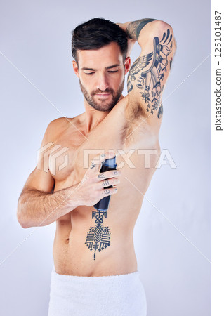 Beauty, fresh and deodorant with a man model spraying perfume to his underarm in studio on a gray background. Product, body and armpit fragrance with a handsome young male in the bathroom alone 125101487