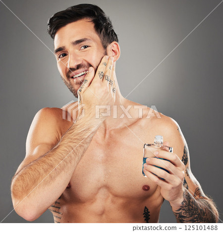 Man, aftershave and skincare portrait for face and beard on a grey studio background for wellness and beauty. Skin care, cologne and man apply product to face for grooming, clean facial hair Man, aftershave and skincare portrait for face and beard on a grey studio background for wellness and beauty. Skin care, cologne and man apply product to face for grooming, clean facial hair 125101488