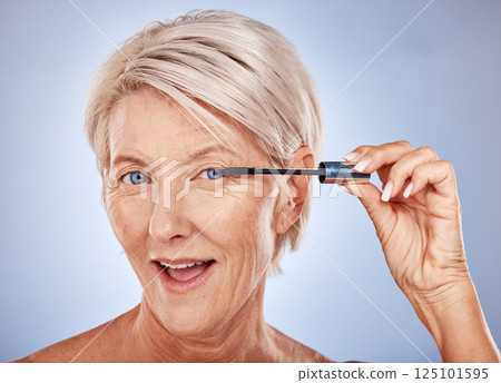 Makeup, mascara and portrait of a senior woman with a natural, cosmetic and beauty routine in a studio. Cosmetics, beautiful and elderly model with a eyelash product isolated by a gray background. Makeup, mascara and portrait of a senior woman with a natural, cosmetic and beauty routine in a studio. Cosmetics, beautiful and elderly model with a eyelash product isolated by a gray background. 125101595