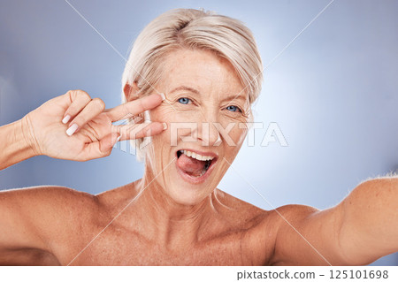 Beauty, peace sign selfie and mature woman for skincare, health and wellness with silly and goofy expression on a studio background. Anti aging, hand gesture and senior female for skin care Beauty, peace sign selfie and mature woman for skincare, health and wellness with silly and goofy expression on a studio background. Anti aging, hand gesture and senior female for skin care 125101698