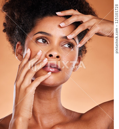 Beauty, hands and face pose of skin model thoughtful feeling healthy, young and soft skin texture. Facial, natural and wellness cosmetic black woman thinking of skincare in orange studio. Beauty, hands and face pose of skin model thoughtful feeling healthy, young and soft skin texture. Facial, natural and wellness cosmetic black woman thinking of skincare in orange studio. 125101728