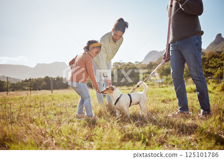 Dog, park and pet family with child, mother and father in nature or a grass field for outdoor wellness. Bonding, love and care of animal or puppy with parents or mom and dad with girl by countryside 125101786