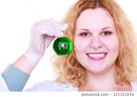 Chemist woman holds test flask 125101839