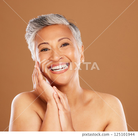 Portrait, beauty and skincare with a mature woman in studio on a brown background for natural treatment. Face, luxury and wellness with a senior female posing to promote a skin antiaging product Portrait, beauty and skincare with a mature woman in studio on a brown background for natural treatment. Face, luxury and wellness with a senior female posing to promote a skin antiaging product 125101944