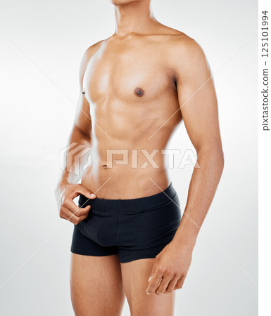 Body, fitness and health with a topless man model posing in underwear in studio on a gray background for wellness. Skin, healthy and natural with a muscular male athlete inside to promote lifestyle 125101994