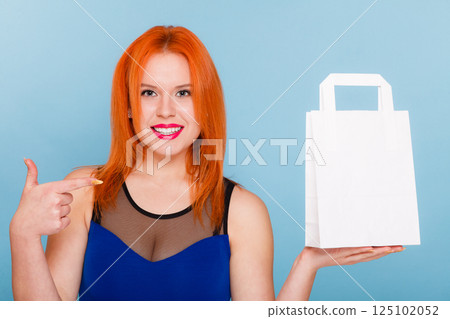 Woman holding paper shopping bag with copy space. Woman holding paper shopping bag with copy space. 125102052