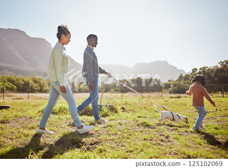 Nature, pet and black family taking a walk with dog having fun, bonding and enjoying summer. Love, animals and mom and dad walking with young girl and puppy in park on weekend, holiday and vacation 125102069