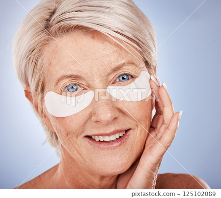 Mature woman, face and eye patch for skincare grooming routine, anti aging treatment or dark circles collagen boost. Zoom, portrait and happy smile on middle aged beauty model with eye facial product 125102089