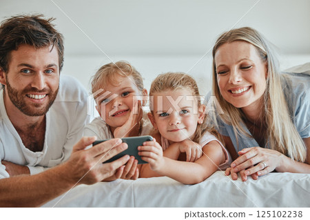 Happy, family and relax with phone on the bed in fun entertainment streaming together at home. Mother, father and children relaxing in the bedroom with smile for online shows on smartphone indoors Happy, family and relax with phone on the bed in fun entertainment streaming together at home. Mother, father and children relaxing in the bedroom with smile for online shows on smartphone indoors 125102238