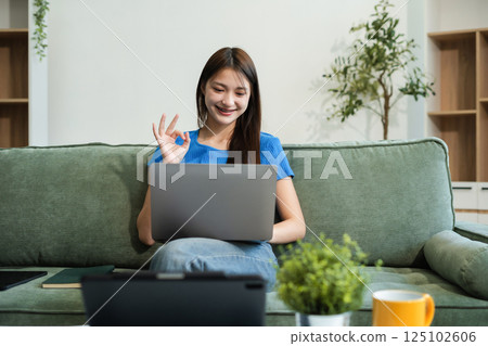 Smiling young woman in headphones taking notes, motivated interested student studying online.Smiling young woman in headphones taking notes, motivated interested student studying online. 125102606