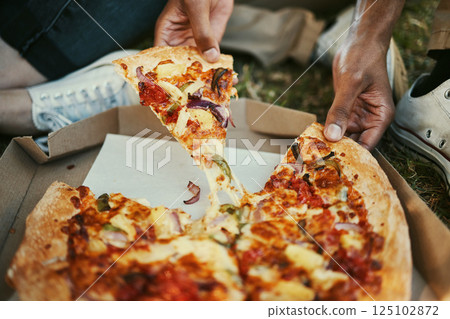 Pizza, food and hands of a couple eating in a park, picnic and relax on an outdoor date together. Hungry, fast food and zoom of man and woman with lunch or dinner in nature for peace and calm 125102872