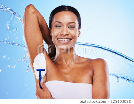Black woman, armpit shaving with cream and razor, beauty for grooming, shower water splash with blue studio background. Hygiene, foam product and clean, skincare portrait and cosmetic hair removal. Black woman, armpit shaving with cream and razor, beauty for grooming, shower water splash with blue studio background. Hygiene, foam product and clean, skincare portrait and cosmetic hair removal. 125103028