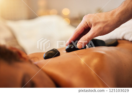 Hand, rock or massage in spa to relax for zen, meditation or wellness physical therapy reiki in resort. Beauty, salon or woman for luxury healthcare, therapy or zoom of hot rocks for energy peace 125103029