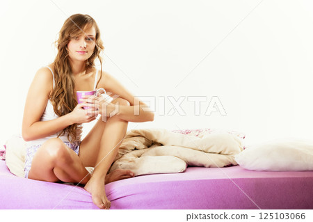 Girl relaxing on bed at morning with tea cup Girl relaxing on bed at morning with tea cup 125103066