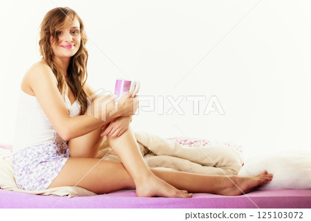 Girl relaxing on bed at morning with tea cup Girl relaxing on bed at morning with tea cup 125103072