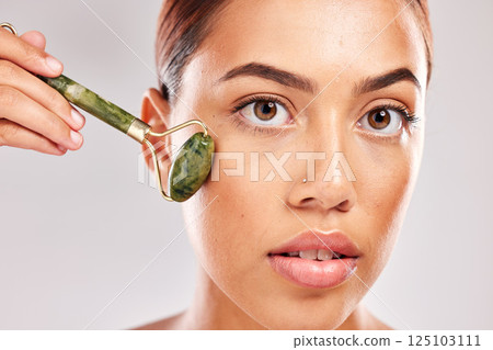 Face roller, skincare and black woman portrait of a model with facial, luxury and massage product. Beauty, skin wellness and dermatology treatment for healthy body glow with natural jade stone 125103111