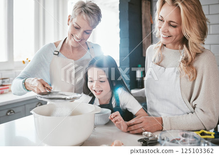 Family, children and baking with a grandmother, mother and daughter in the kitchen together for learning. Food, cooking and kids with a woman, parent and girl bonding in the house to bake a pastry Family, children and baking with a grandmother, mother and daughter in the kitchen together for learning. Food, cooking and kids with a woman, parent and girl bonding in the house to bake a pastry 125103362