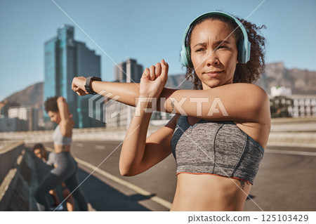 Fitness, city and people stretching with headphone music, podcast or streaming in Canada. Exercise, friends and black people getting ready for urban run workout together with arm stretch. 125103429