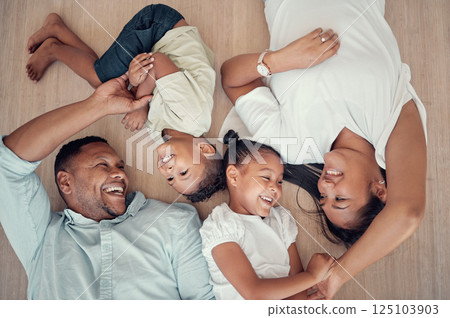 Top view, happy family or bonding on floor in house living room, family home bedroom or Indonesian hotel. Smile, children or kids with mother, father or parents lying on ground in trust, play or love 125103903