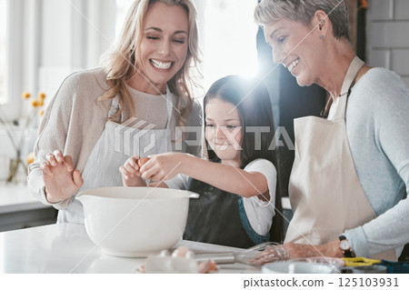 Baking, excited and girl with mother and grandmother in the kitchen cooking as a team. Food, teamwork and child with mom and senior woman learning to crack an egg while helping with dinner in a house 125103931