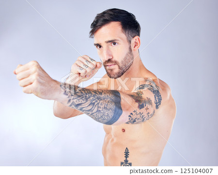 Man, boxing and punching on studio background in fitness workout, body training or exercise for competition fight, anger management or stress control. Boxer, sports athlete and mma model with tattoos Man, boxing and punching on studio background in fitness workout, body training or exercise for competition fight, anger management or stress control. Boxer, sports athlete and mma model with tattoos 125104007